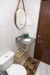 a bathroom with a toilet and a sink and a mirror at Casa Pé na Areia, Praia de Cotovelo Natal RN in Parnamirim +37 photos