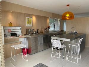 a kitchen with a counter and some chairs in it at Appartement pieds dans l'eau, Locquirec in Locquirec
