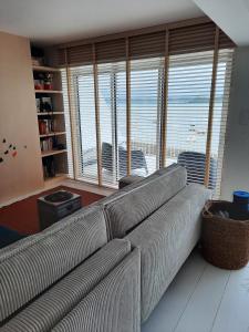 a living room with a couch and a large window at Appartement pieds dans l'eau, Locquirec in Locquirec