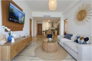 un soggiorno con un divano e una TV di Apartamento Moderno en Playa Dorada Piscina & Playa a Puerto Plata