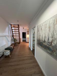 a hallway with a staircase and paintings on the wall at FeWo Storchennest in Schönberg