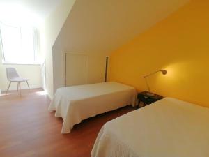 1 dormitorio con 2 camas, lámpara y silla en Blue Terrace, en Alcochete 8 fotos más