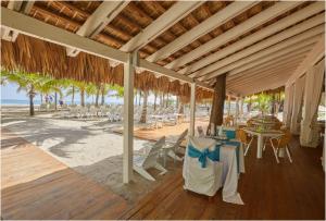 un padiglione con tavolo e sedie sulla spiaggia di Apartamento Moderno en Playa Dorada Piscina & Playa a Puerto Plata
