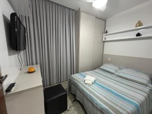 a hotel room with a bed and a television at Raridade Cachoeiro, Apto 2 Qtos, Ar, Ferroviários in Cachoeiro de Itapemirim +7 photos