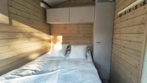 ムオニオにあるLapland Landscape XXL Cabin with Nature View, Sauna, Fireplace & Kitchen, Sodankylä, Luosto, Fell Villageの木製の壁のドミトリールームのベッド1台分です。