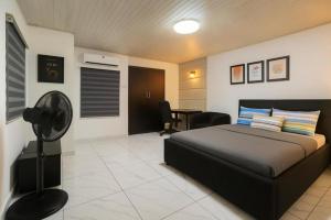 a bedroom with a bed and a desk with a fan at Easyinn Shortlet Apartment in Port Harcourt