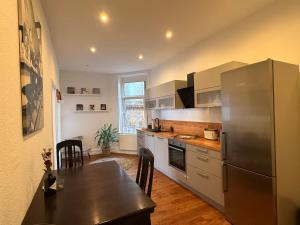 a kitchen with a stainless steel refrigerator and a table at Entspannt Mittendrin in Hannover