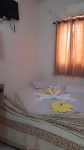 a bed with towels on it with a window at Pousadaa São João 144 in Aparecida