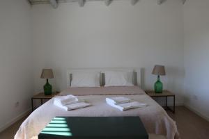 a bedroom with a bed with two towels on it at Casa da Moura in Santiago do Cacém