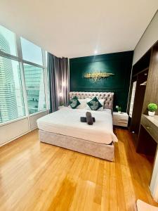 una camera da letto con un letto grande con una parete verde di Sky Premium Apartment Klcc a Kuala Lumpur