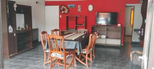 a kitchen with a table and chairs and a red wall at PompinHouse in Ushuaia