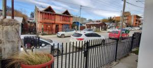 a fence with cars parked in a parking lot at PompinHouse in Ushuaia