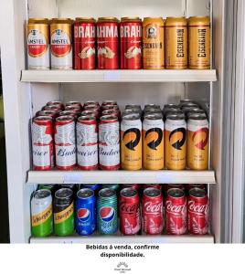 a refrigerator filled with lots of cans of soda at Hotel Girassol in Imbé