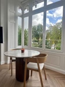 a table and a chair in a room with a window at Suite Arche - Maison les Arcades au pied de la Gare de Charleville-Mézières in Charleville-Mézières