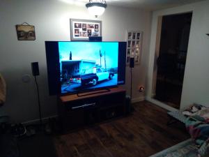 a flat screen tv sitting on a stand in a living room at Cozy 2 Bedroom Home in Madison