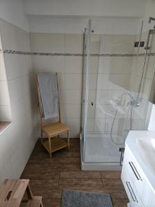 a bathroom with a shower and a chair next to a sink at Modern and quiet apartment in Bad Sooden-Allendorf in Bad Sooden-Allendorf