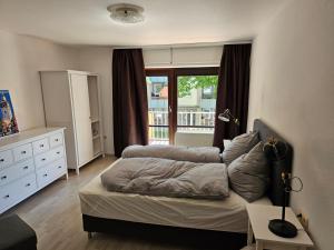 a bedroom with a bed and a dresser and a window at Modern and quiet apartment in Bad Sooden-Allendorf in Bad Sooden-Allendorf