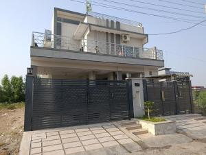 a house with a black gate and a balcony at RMT Residencia in Peshawar