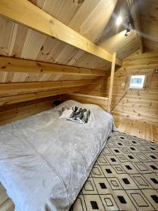 La Celle-sous-GouzonにあるChalet natureの木造キャビン内のベッド1台が備わるベッドルーム1室を利用します。