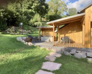 La Celle-sous-GouzonにあるChalet natureの木製デッキ(グリル付)のある家