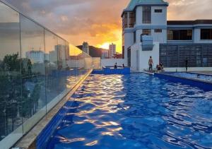 a infinity pool on the roof of a building with the sunset at CSJ Apartment Sea View Vung Tau - Căn Hộ CSJ Tầm nhìn biển , Tháp Tam Thắng Vũng Tàu in Vung Tau