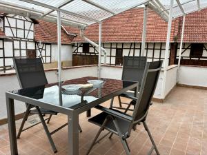 una mesa y sillas en un patio con techo en Landhaus Himmelsbach 22, en Beuernfeld