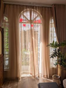 an arched window with curtains in a room at Maison Maravelle Hotel - Boutique Stay in Hanoi Old Quarter in Hanoi