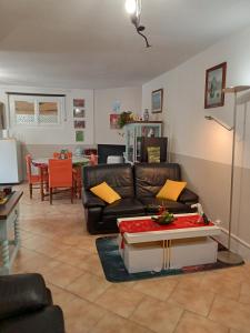 a living room with a couch and a table at une pause quelque part au jardin des érables et des niwakis in Saint-Médard-de-Guizières
