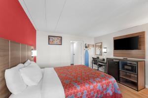 a hotel room with a bed and a flat screen tv at Econo Lodge Cranston - Providence in Cranston