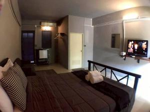 a bedroom with a bed with a tv on the wall at Laanrablom Bed&Breakfast in Sara Buri