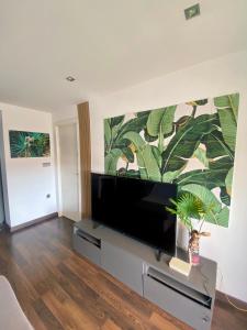 Una sala de estar con un televisor de pantalla plana sobre un soporte. en Calm Jungle Apartment Near Valencia, en Aldaia
