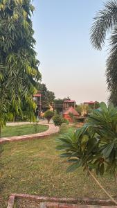 a park with a path and trees and a building at GardenView Hotel and Resort in Dhantori