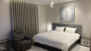 un dormitorio con una cama y una silla en Rfaa Suites, en Medina