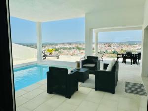 a living room with a pool and a table and chairs at Vila Pombal Tomar - Luxury Apartment with private pool and Castle View in Tomar