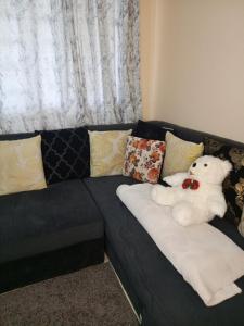 a white teddy bear sitting on a couch at Petra homes in Nyeri