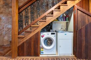 Waschmaschine und Trockner unter einer Treppe in der Unterkunft Adelaide Heritage Home with Vintage Charm in Evandale