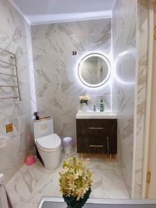 une salle de bain avec toilettes, lavabo et miroir dans l'établissement 18А Premium Plaza, à Aktau