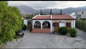 una pequeña casa con un coche aparcado delante de ella en A Spacious Villa to Entertain, en Aglantzia