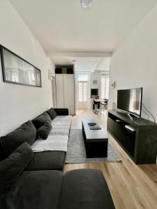 Una sala de estar con un sofá y un televisor. en T2 35 m2 République Vieux-Port, joliette, en Marsella