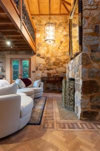 ein Wohnzimmer mit einer Steinmauer und weißen Möbeln in der Unterkunft Adelaide Heritage Home with Vintage Charm in Evandale