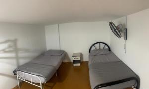una habitación con dos camas en una habitación en Sungai Udang Homestay 4 bilik dengan 2 loteng atas, en Melaka