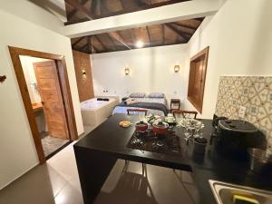 a kitchen with a counter top and a living room at Riquezas de Lavras Novas - Chalé Safira in Lavras Novas
