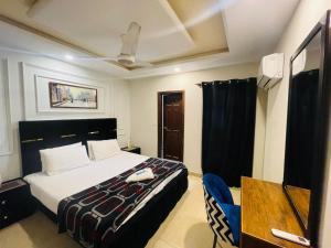 a bedroom with a bed and a desk and a television at Modern 2BHK Islamabad in Islamabad