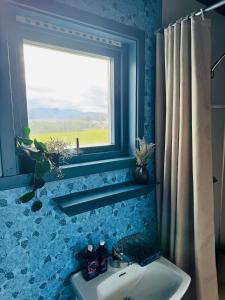 トロムソにあるCentral and rural house with beautiful viewの青いバスルーム(シンク、窓付)
