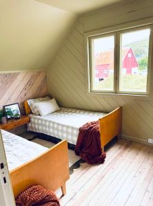 トロムソにあるCentral and rural house with beautiful viewのベッドが2つと窓のある部屋