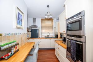 a kitchen with white cabinets and a wooden counter top at Marketplace Glastonbury in Glastonbury +51 photos