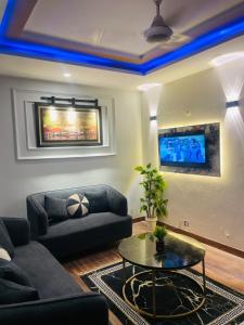 a living room with a couch and a table at Modern 2BHK Islamabad in Islamabad
