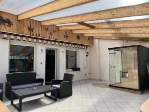 a patio with a wooden ceiling and a table and chairs at Kurpark Ferienwohnung in Schleiden