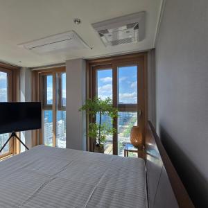una camera da letto con un letto e una grande finestra di 원스테이 가산디지털단지 a Seul