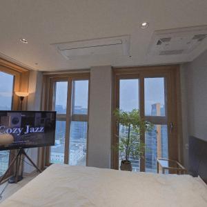 una camera con letto, TV e finestre di 원스테이 가산디지털단지 a Seul